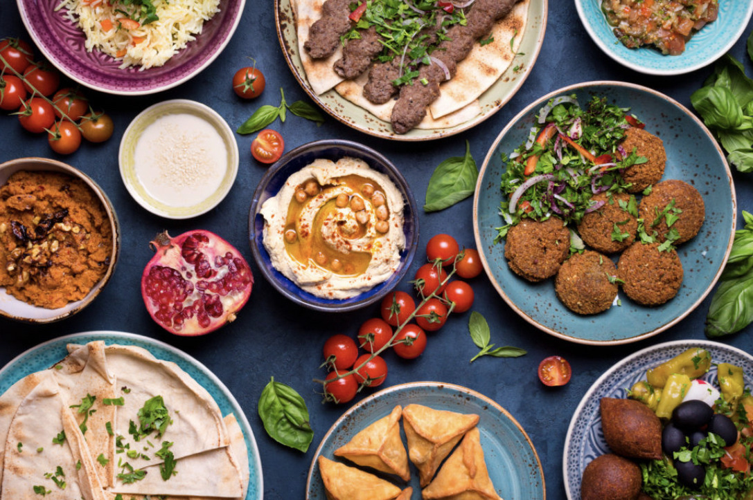 Libanese mezze op tafel: hummus, falafel, granaatappel, tomaatjes en meer